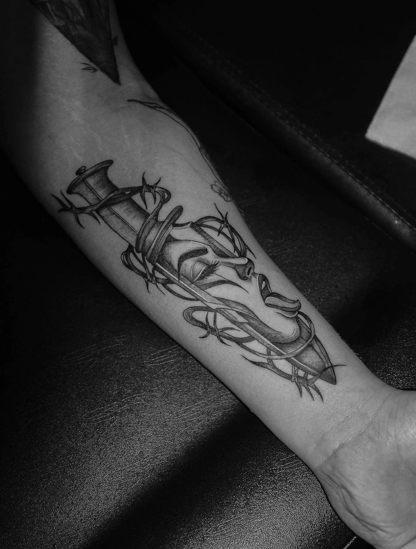 Schwarz-graues Unterarmtattoo einer Frau mit Zylinder, Rasiermesser und Dornen